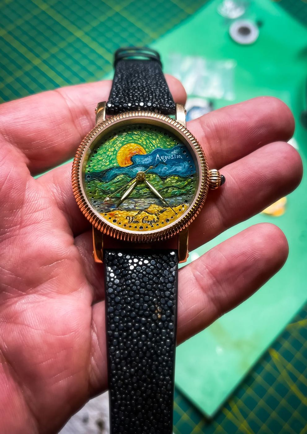 Ceasul Van Gogh în palmă, cu soarele, norii și câmpul pictate pe cadran